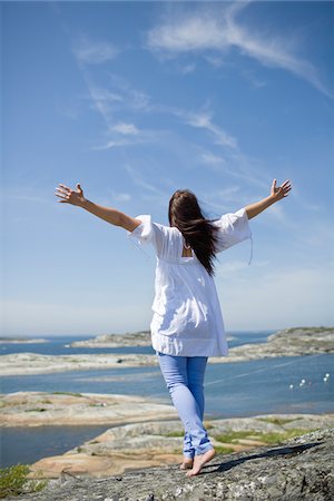 simsearch:632-03652079,k - Woman standing on rock with arms up Fotografie stock - Premium Royalty-Free, Codice: 6102-04929640