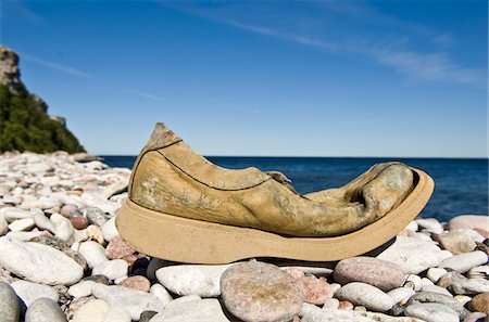 dropped in water nobody - Old damaged shoe on stone beach Stock Photo - Premium Royalty-Free, Code: 6102-04929789