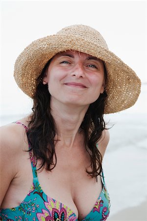 simsearch:6102-08566996,k - Woman wearing straw hat smiling, portrait Stock Photo - Premium Royalty-Free, Code: 6102-04929738