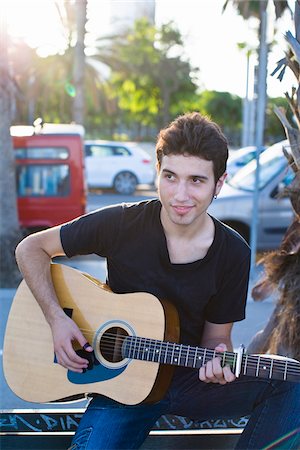 Portrait of young man playing guitar, outdoors Stock Photo - Premium Royalty-Free, Code: 6102-04929800