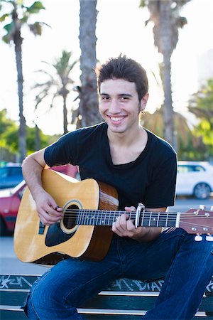 Portrait of young man playing guitar, outdoors Stock Photo - Premium Royalty-Free, Code: 6102-04929801