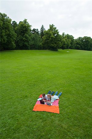 Couple with laptops lying on blanket in park Stock Photo - Premium Royalty-Free, Code: 6102-04929912