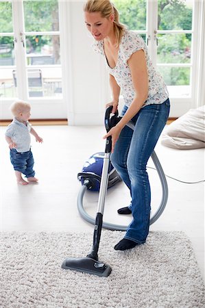 picture of person vacuuming - Mother vaccuming the livingroom Stock Photo - Premium Royalty-Free, Code: 6102-05655494