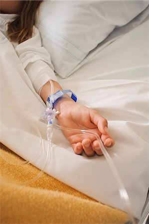 sick children in hospital - Girl lying on hospital bed with IV drip on arm Stock Photo - Premium Royalty-Free, Code: 6102-05655547