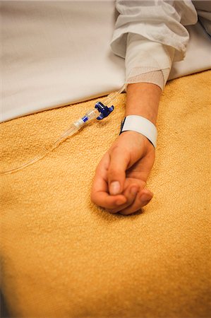 Girl lying on hospital bed with IV drip on arm Stock Photo - Premium Royalty-Free, Code: 6102-05655548