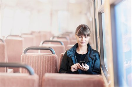 Femme sur le bus à l'aide de téléphone portable Photographie de stock - Premium Libres de Droits, Code: 6102-05603673