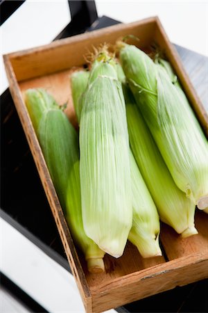 stacked vegetables - Close up of corn cobs in wooden crate Stock Photo - Premium Royalty-Free, Code: 6102-05802588