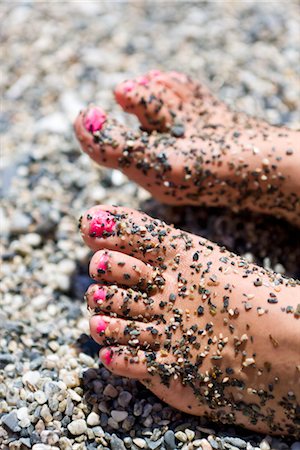 Gros plan des pieds des filles avec des vernis à ongles rose recouverte de pierres de galet Photographie de stock - Premium Libres de Droits, Code: 6102-05802610