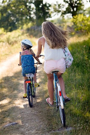 preteen girls backsides - Filles du vélo sur le chemin d'accès Photographie de stock - Premium Libres de Droits, Code: 6102-05802615