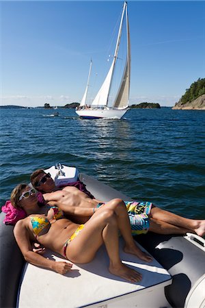 simsearch:6102-03751079,k - Young couple sunbathing on dinghy Foto de stock - Royalty Free Premium, Número: 6102-05955870