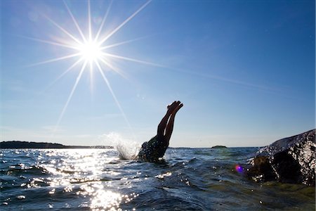 diving men - Young man jumping into water Stock Photo - Premium Royalty-Free, Code: 6102-05955875