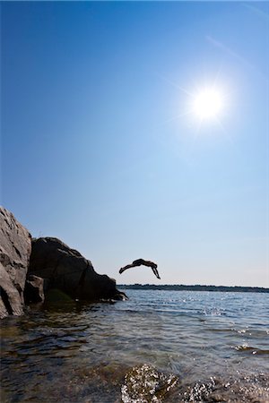 Man jumping from cliff into sea Foto de stock - Sin royalties Premium, Código: 6102-05955903