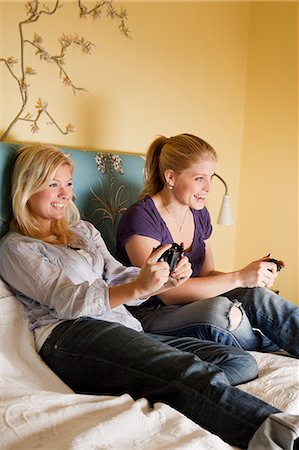 emotional attachment - Two young women playing video game in bedroom Foto de stock - Sin royalties Premium, Código: 6102-06025794