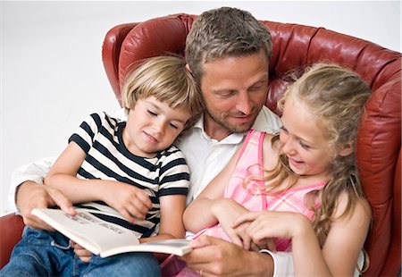 simsearch:6102-08996269,k - Father reading to kids Foto de stock - Sin royalties Premium, Código: 6102-06025845