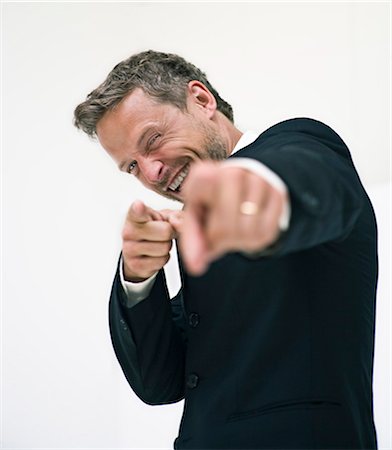 seller - Studio portrait of businessman pointing Stock Photo - Premium Royalty-Free, Code: 6102-06025846