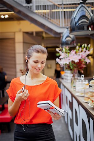 education communications - Young woman talking on mobile phone using earbud Stock Photo - Premium Royalty-Free, Code: 6102-06025899