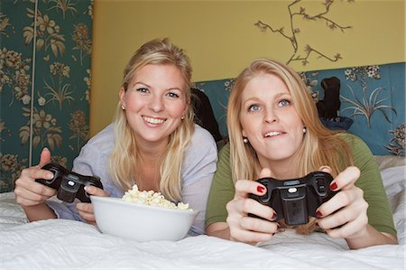 emotional attachment - Two young women playing video game in bedroom Foto de stock - Sin royalties Premium, Código: 6102-06025806