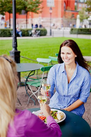 simsearch:6102-07158237,k - Two women toasting wine at outdoor cafe Foto de stock - Sin royalties Premium, Código: 6102-06025944