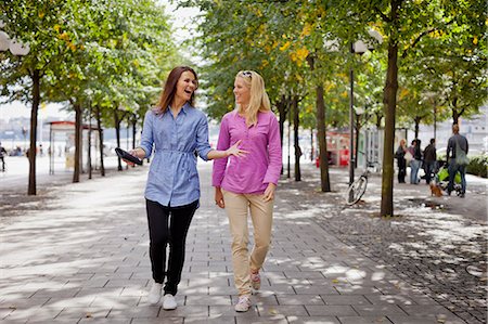 friend vacation adults not looking at camera not child - Two friends walking in park Stock Photo - Premium Royalty-Free, Code: 6102-06025938