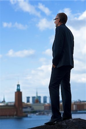 simsearch:6102-07158142,k - Mature man standing and looking at Stockholm City Hall Foto de stock - Sin royalties Premium, Código: 6102-06026096