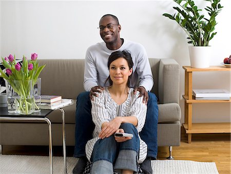 Portrait of couple sitting in living room and watching TV Stock Photo - Premium Royalty-Free, Code: 6102-06026028