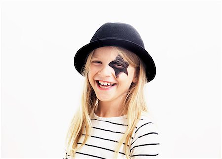 painted face - Smiling girl wearing hat, studio shot Stock Photo - Premium Royalty-Free, Code: 6102-06374469