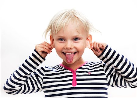 Portrait of girl sticking out tongue, studio shot Stock Photo - Premium Royalty-Free, Code: 6102-06374472