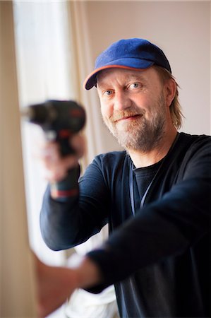 diy or home improvement - Portrait of smiling man drilling Foto de stock - Sin royalties Premium, Código: 6102-06374536