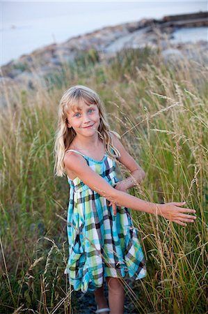 simsearch:6102-06336526,k - Portrait of smiling girl standing in tall grass Foto de stock - Royalty Free Premium, Número: 6102-06336561