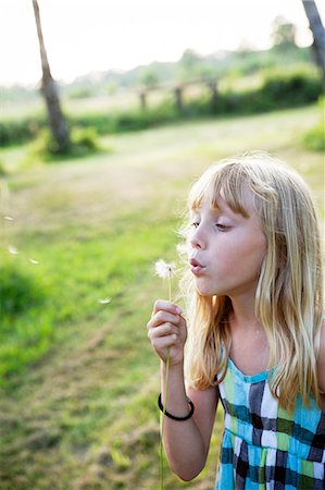 Girl blowing dandelion Stock Photo - Premium Royalty-Free, Code: 6102-06336564