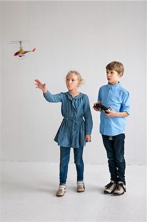 Garçon et fille jouant avec le modèle d'hélicoptère Photographie de stock - Premium Libres de Droits, Code: 6102-06336642