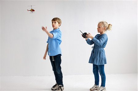 Garçon et fille jouant avec le modèle d'hélicoptère Photographie de stock - Premium Libres de Droits, Code: 6102-06336644