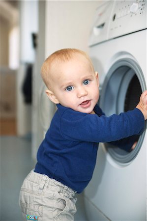 simsearch:6102-06336624,k - Baby boy trying to stand next to washing machine Foto de stock - Sin royalties Premium, Código: 6102-06336661