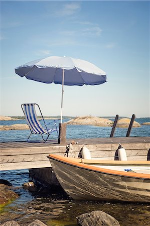 relaxing on a dock - Deck chair and sunshade on jetty Stock Photo - Premium Royalty-Free, Code: 6102-06336780