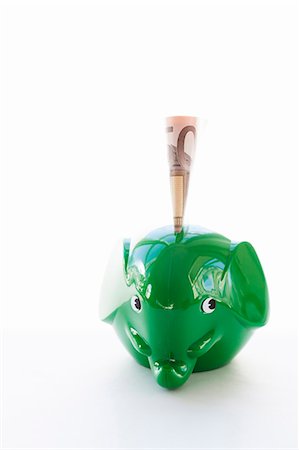 Elephant-shaped piggy bank with money Stock Photo - Premium Royalty-Free, Code: 6102-06336995