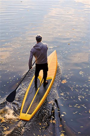 simsearch:6102-06336948,k - Man rowing paddle board in water, elevated view Foto de stock - Sin royalties Premium, Código: 6102-06336936