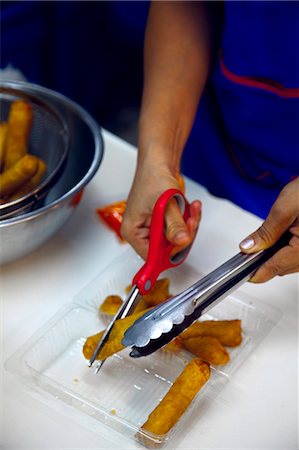 Person cutting deep fried spring rolls, close-up Stock Photo - Premium Royalty-Free, Code: 6102-06337090