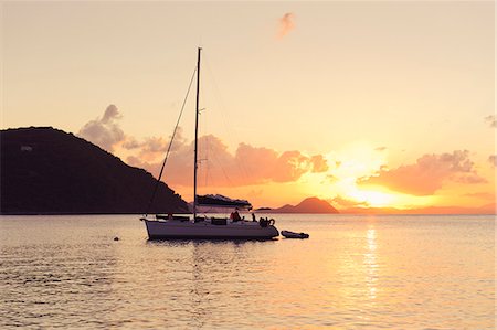 sailboat  ocean - Sailing boat against sunset Stock Photo - Premium Royalty-Free, Code: 6102-06337119