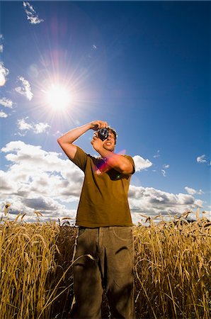 simsearch:6102-08995217,k - Man taking photographs in a field, Sweden. Foto de stock - Royalty Free Premium, Número: 6102-06470617