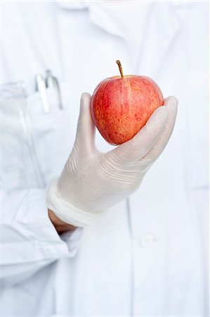 fruits and vegetables on white background - Laboratory technician holding apple Stock Photo - Premium Royalty-Free, Code: 6102-06470873