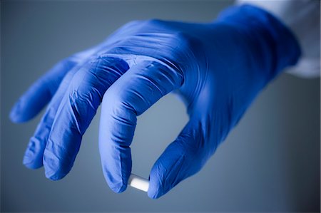 Hand in blue surgical glove holding capsule Foto de stock - Sin royalties Premium, Código: 6102-06470931