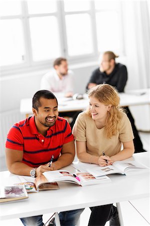 simsearch:6102-06471137,k - Happy students studying in library Foto de stock - Sin royalties Premium, Código: 6102-06471129