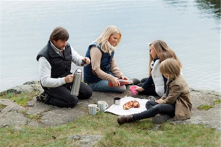 simsearch:6102-06777347,k - Family with two kids enjoying picnic by lake Foto de stock - Sin royalties Premium, Código: 6102-06777352