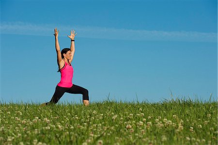 Woman stretching in meadow Stock Photo - Premium Royalty-Free, Code: 6102-06777478