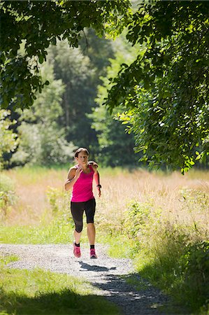 Woman jogging in park Stock Photo - Premium Royalty-Free, Code: 6102-06777493