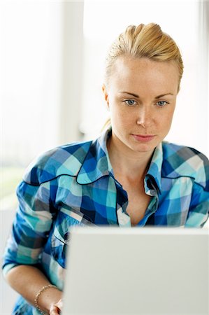 simsearch:6102-08942362,k - Young woman working on laptop Stock Photo - Premium Royalty-Free, Code: 6102-06777548