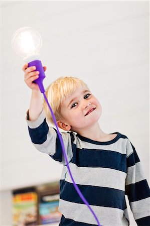 power child - Boy holding illuminated light bulb Stock Photo - Premium Royalty-Free, Code: 6102-06777575