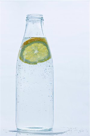 Studio shot of water bottle with slice of lemon Foto de stock - Sin royalties Premium, Código: 6102-06777593