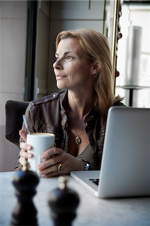 Businesswoman sitting in office with mug Foto de stock - Sin royalties Premium, Código: 6102-06777507