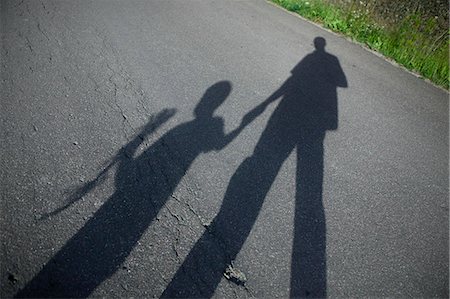 simsearch:6102-06337043,k - Shadow of father and boy on road Photographie de stock - Premium Libres de Droits, Code: 6102-06777602